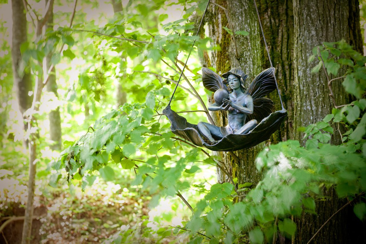 Sculpture en forme d'elfe suspendue à un arbre de l'enchanted woodland du Château de Vullierens.