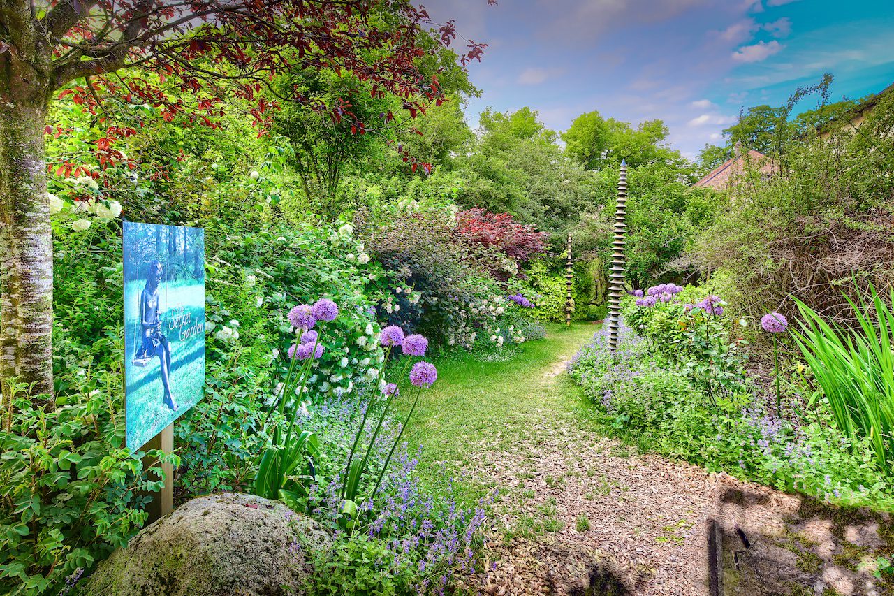 Le jardin secret du Château de Vullierens fleuris d'alliums violets et de verdures de couleurs vives.