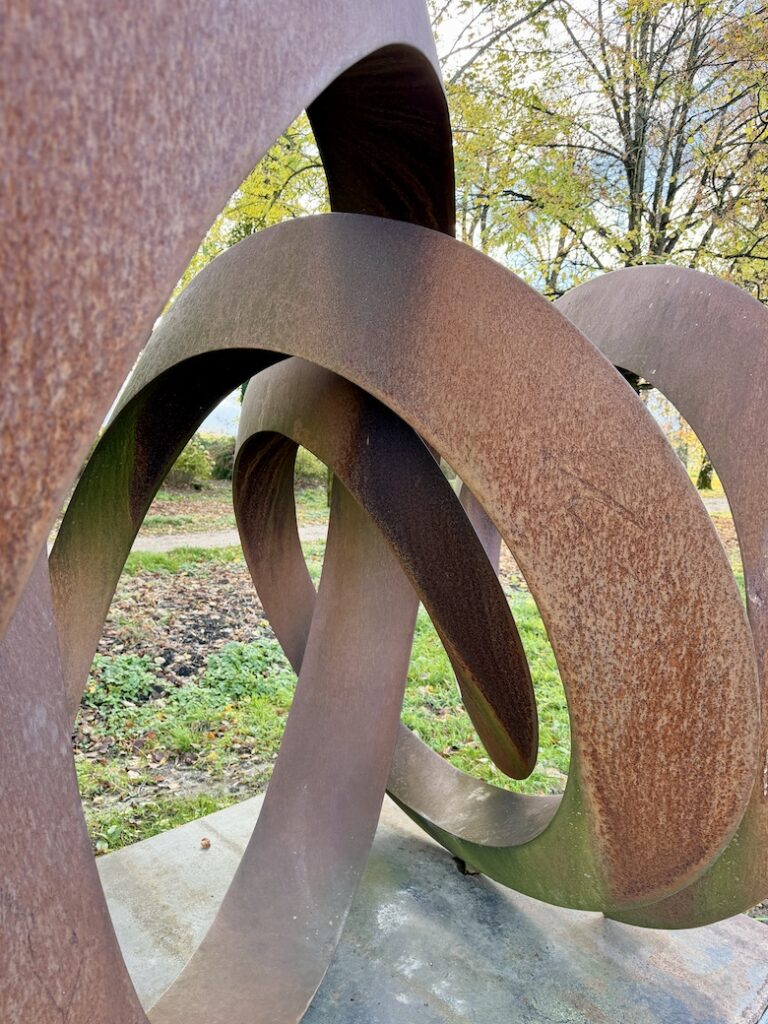 Vue rapprochée de l'oeuvre métallique de Pieter Obels, sur fond d'automne.