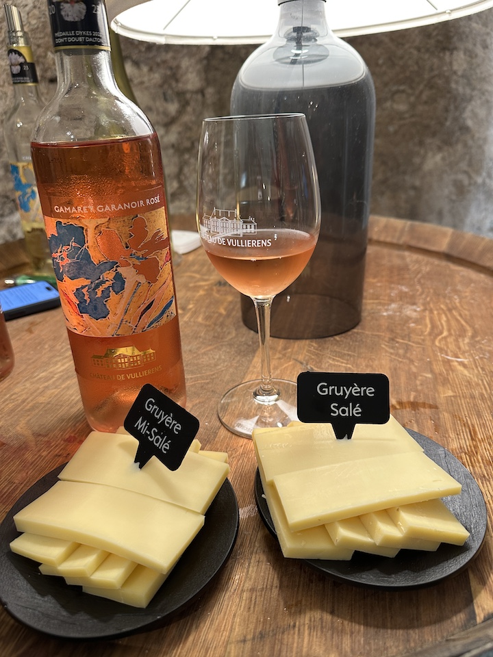 Photo prise lors de la dégustation Vins et fromages dans la cave privée du Château, on y voit une bouteille de rosé de gamaret garanoir ainsi que du gruyère coupé en morceaux.