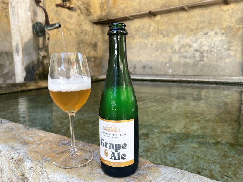 Bouteille de bière posée sur le rebord de la fontaine dans la cour du Château.