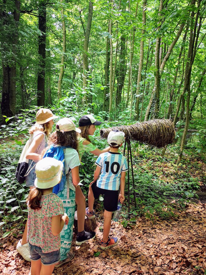 5 enfants découvrant le Royaume du Roi Lézard du Château de Vullierens en été, ils jouent avec une longue vue en bois