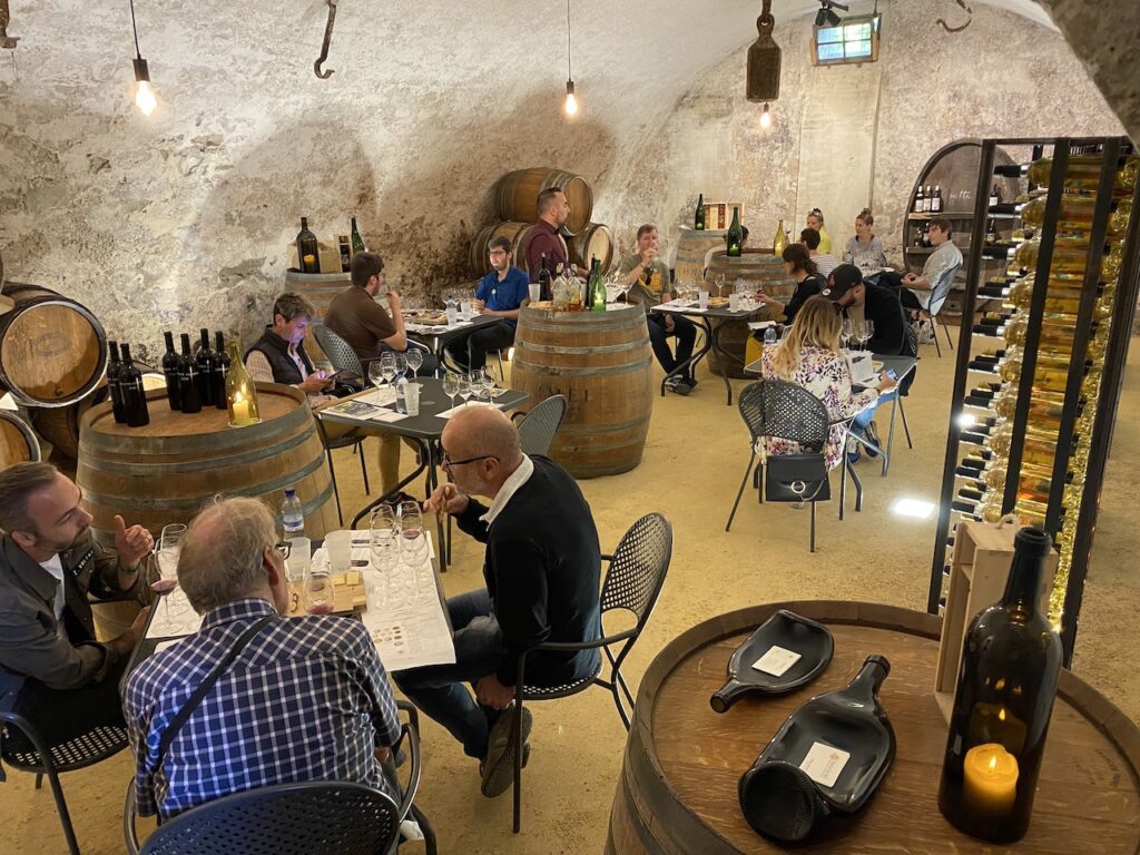 Mise en place de la cave privée du Château de Vullierens lors d'une dégustation de vins public, les tables sont réparties les unes à côtés des autres par réservation.