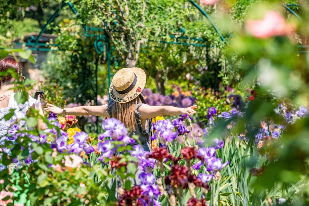 2 femmes en train de se prendre en photos au milieu des iris en fleurs du jardin de Doreen du Ch&acirc;teau de Vullierens.
