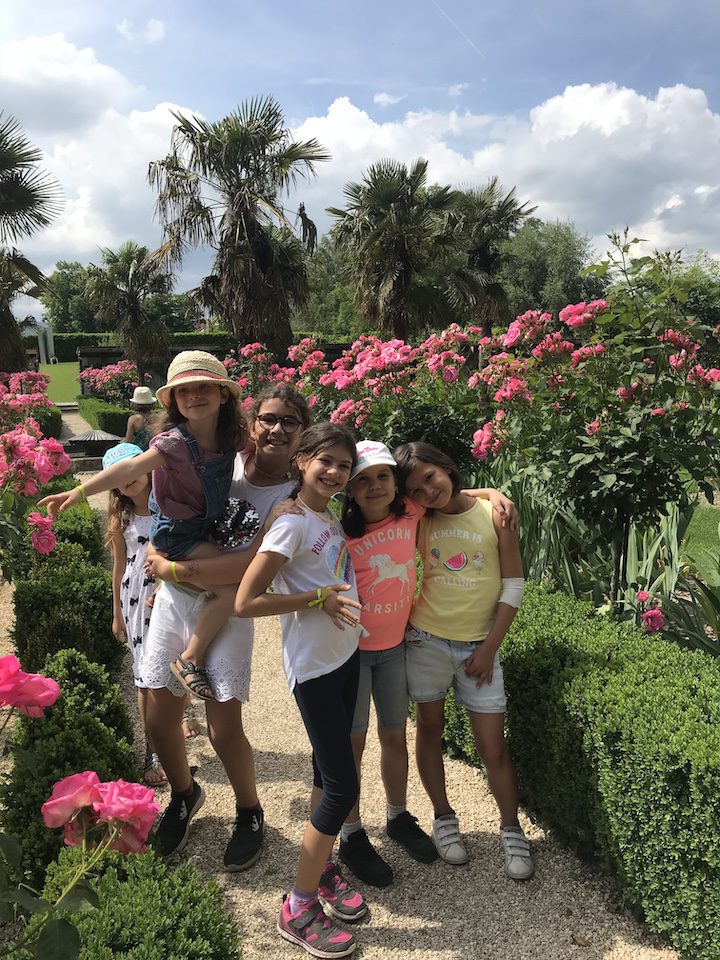 6 petites filles en train de s'amuser dans les all&eacute;es de rosiers en fleurs dans le jardin de Doreen du Ch&acirc;teau de Vullierens.