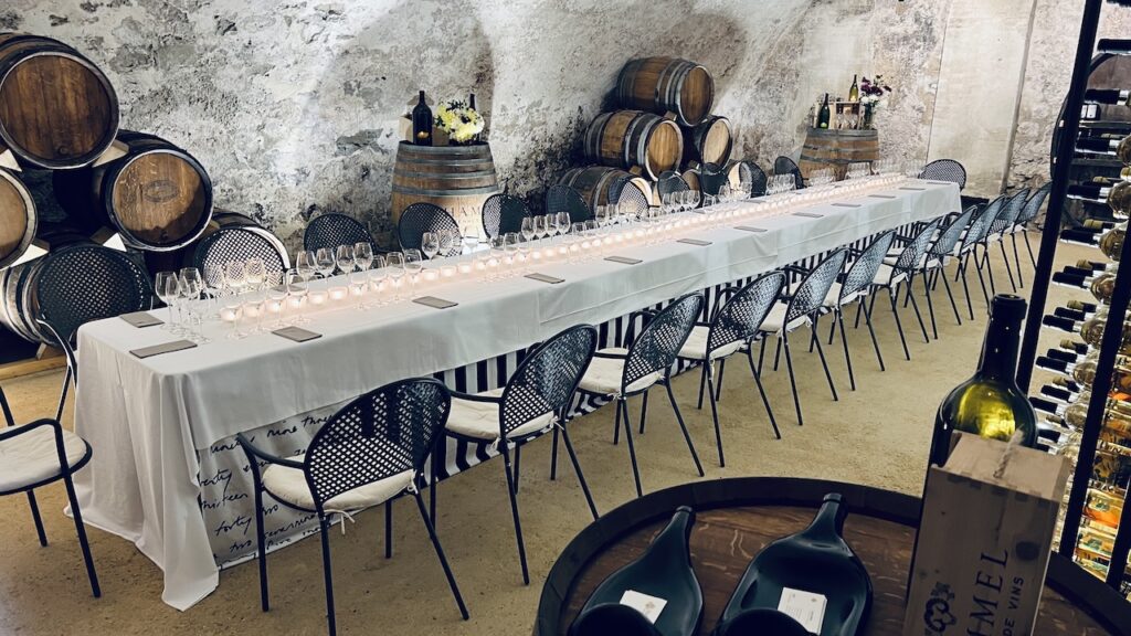 Longue table dressée dans la cave privée du Château de Vullierens pour une dégustation.