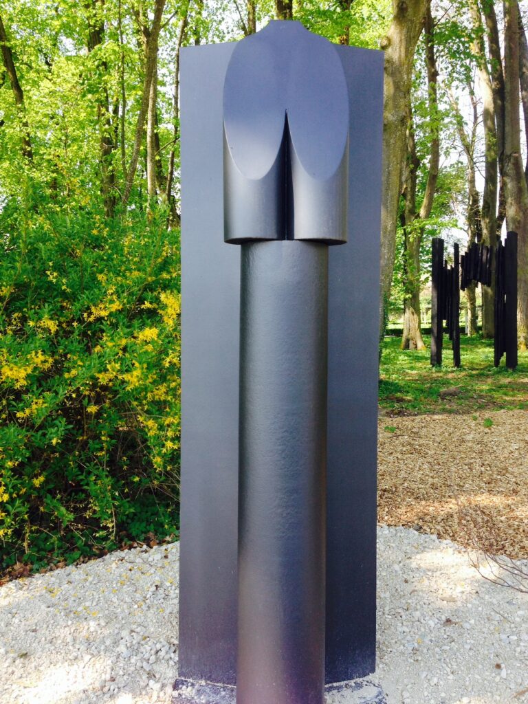 Oeuvre de Manuel Torres de couleur noire exposée sous les grands arbres du jardin de Daria, au Château de Vullierens.