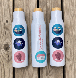 Gourde isotherme aux couleurs du Château de Vullierens. Cette gourde est vendue en ligne et sur place dans la boutique. Les dessins sur la gourde sont : le chateau, un panier pique-nique, un iris violet et la sculpture de Beverly Pepper.