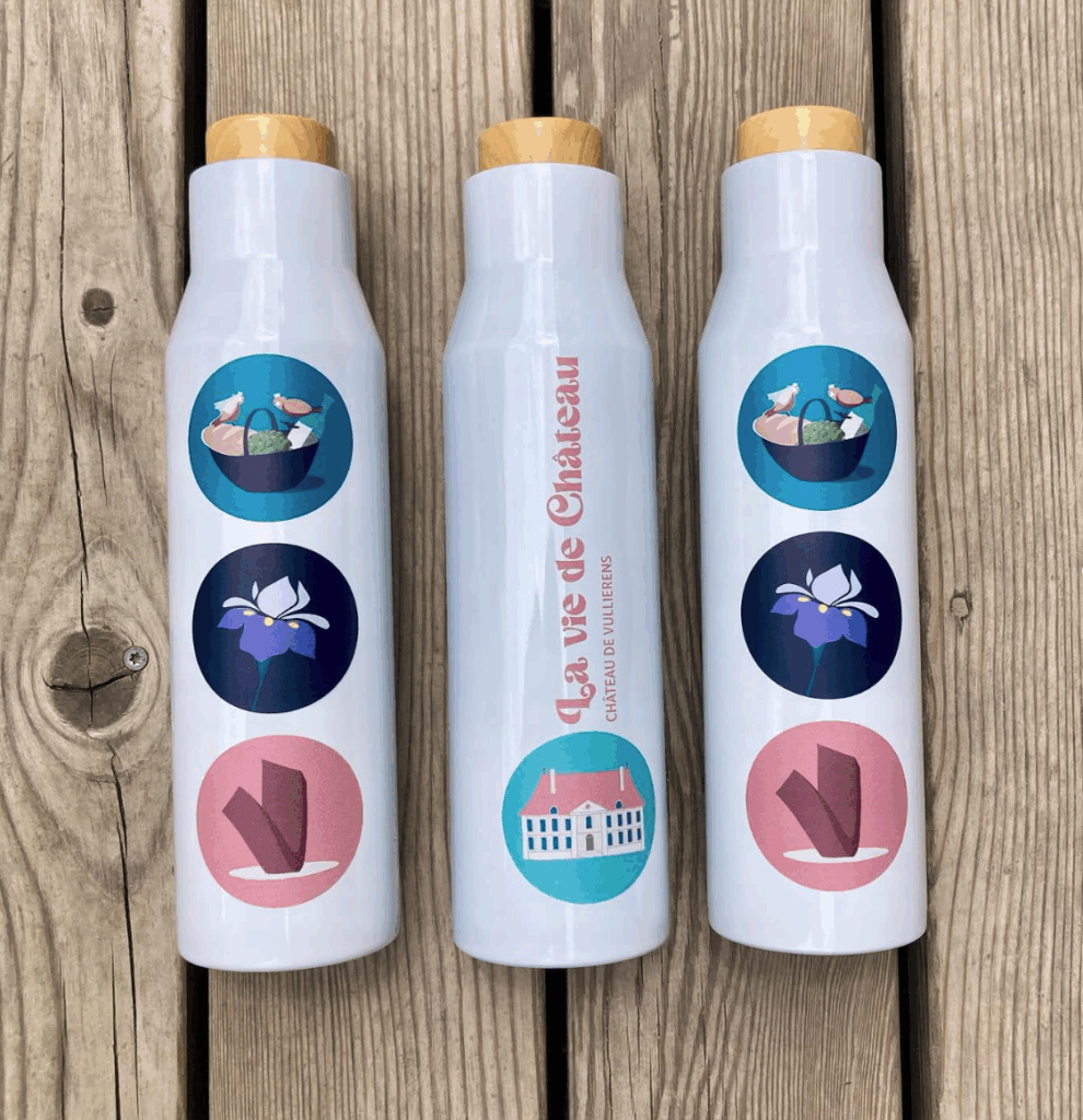 Gourde isotherme aux couleurs du Château de Vullierens. Cette gourde est vendue en ligne et sur place dans la boutique. Les dessins sur la gourde sont : le chateau, un panier pique-nique, un iris violet et la sculpture de Beverly Pepper.
