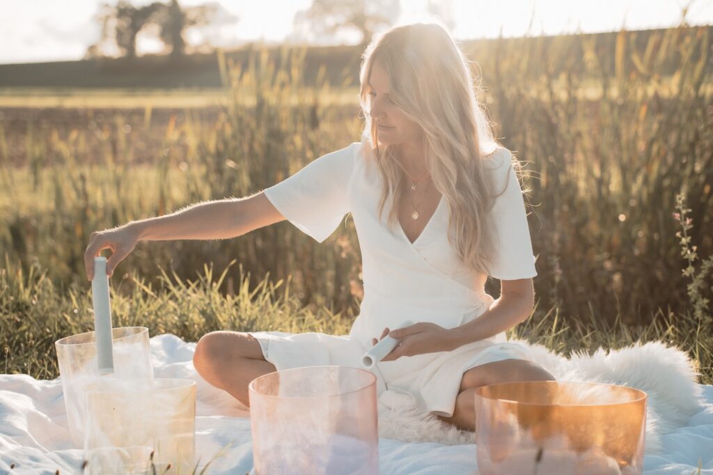 Mary-Noëlle en pleine action lors de son atelier de petite parenthèse pour soi dans nos jardins. Elle fait appel à des bols en cristal.