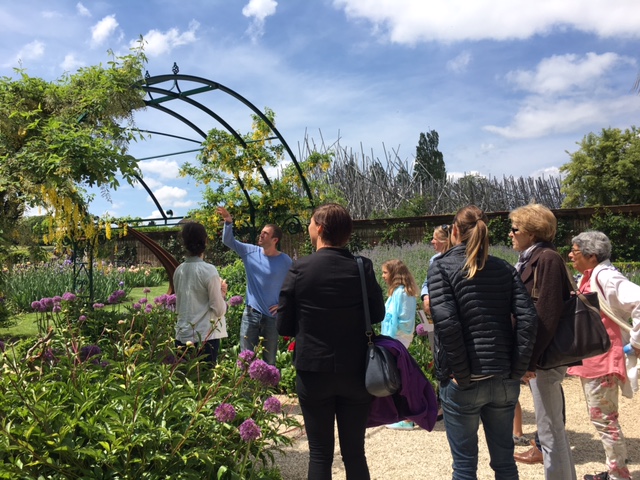 Un petite groupe d'adulte assistant à une visite guidée dans le jardin de Doreen du Château de Vullierens.